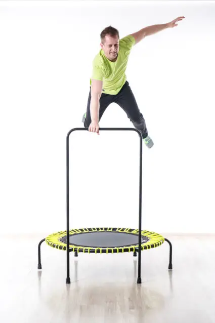 A man performs a dynamic jump on a trampoline, capturing a moment of excitement and physical activity.
