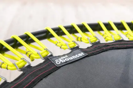 Close-up image of a trampoline with striking yellow and black straps, illustrating the unique design and robust features.