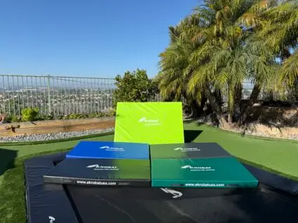 AkrobatUSA Landing Mat 15 A trampoline featuring four distinct colored squares arranged on its surface, showcasing vibrant hues for playful activity.