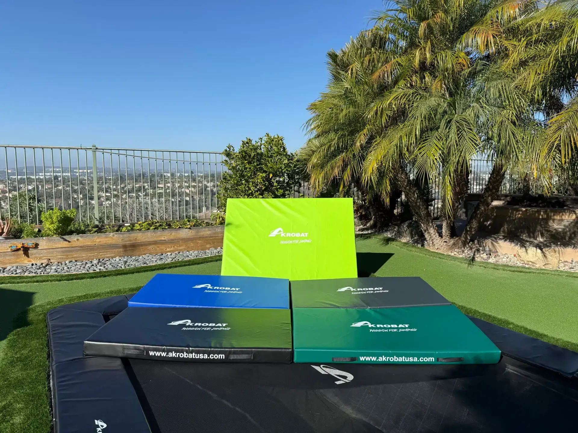 AkrobatUSA Landing Mat 8 A trampoline featuring four distinct colored squares arranged on its surface, showcasing vibrant hues for playful activity.