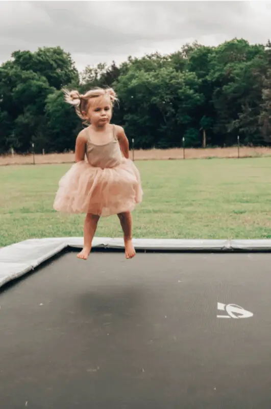 girl jumping on rectangular trampoline